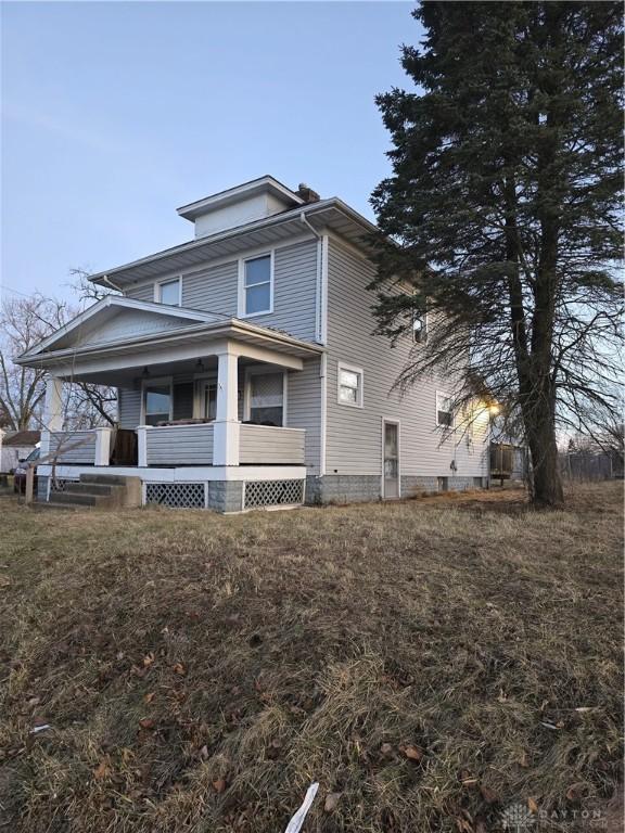 view of side of property with a porch