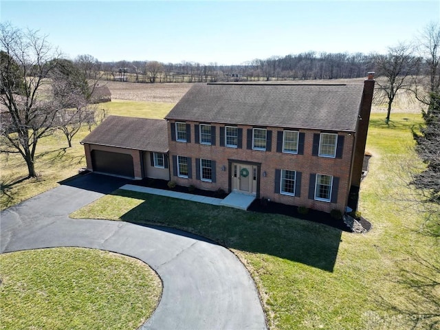 view of front of property with a front lawn, a garage, driveway, and a chimney