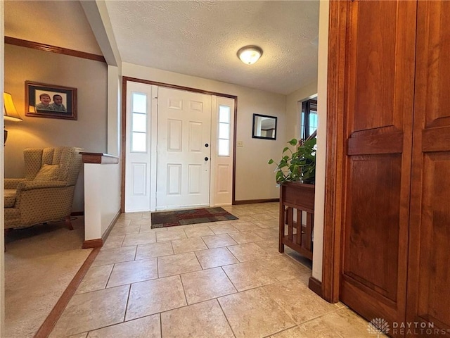 entrance foyer with a wealth of natural light, baseboards, and a textured ceiling