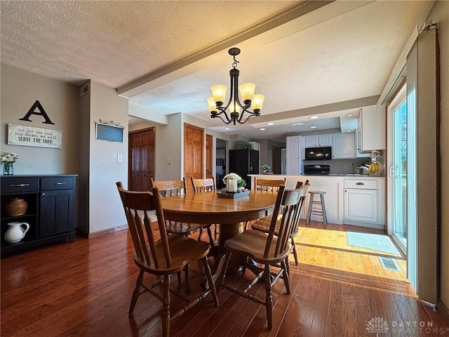 dining area featuring wood-type flooring, a textured ceiling, and a chandelier