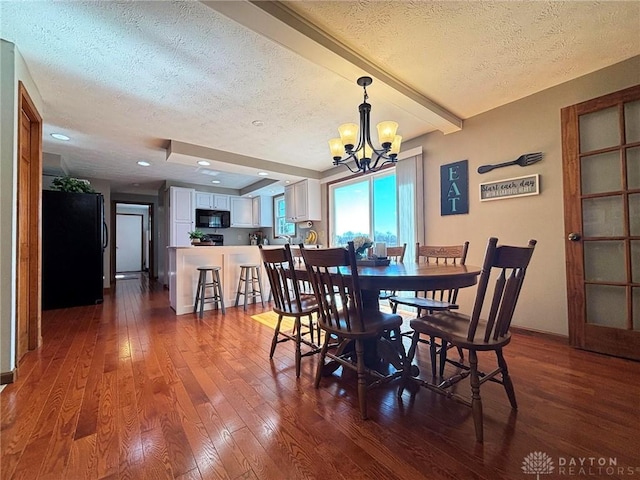 dining room featuring a chandelier, baseboards, a textured ceiling, and dark wood finished floors