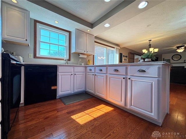 kitchen featuring black dishwasher, a peninsula, an inviting chandelier, dark wood-style floors, and white cabinetry