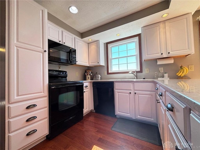 kitchen featuring light countertops, dark wood-style floors, white cabinets, black appliances, and a sink