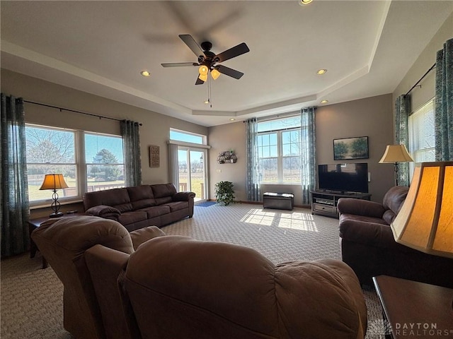 carpeted living room featuring recessed lighting, a raised ceiling, and ceiling fan