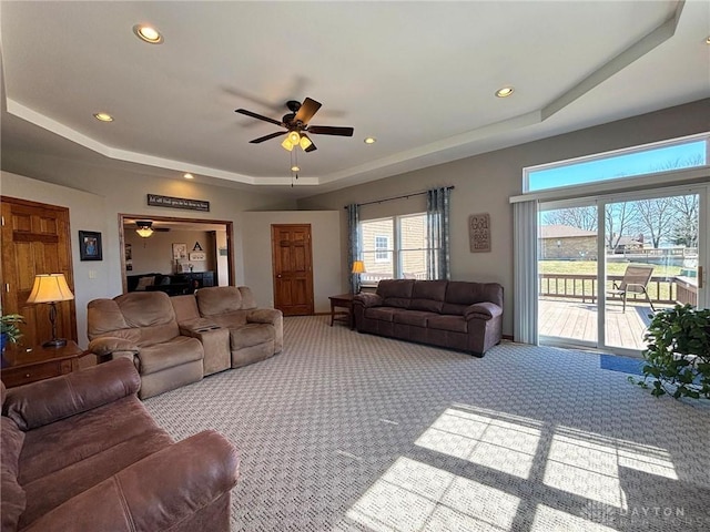 carpeted living area with recessed lighting, a raised ceiling, and ceiling fan