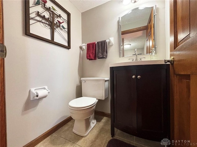 half bathroom featuring baseboards, toilet, vanity, tile patterned floors, and a textured ceiling