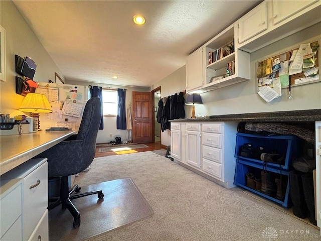 home office with recessed lighting, light carpet, and built in desk