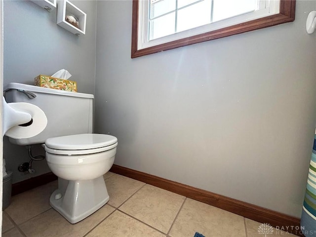 bathroom with tile patterned floors, baseboards, and toilet