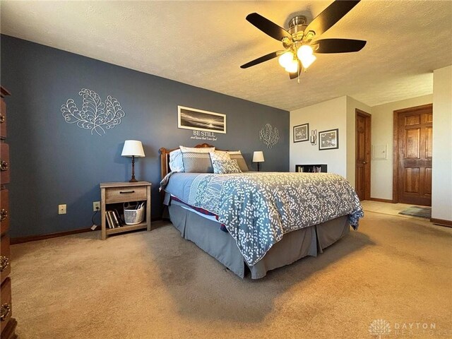 bedroom with baseboards, carpet, ceiling fan, and a textured ceiling