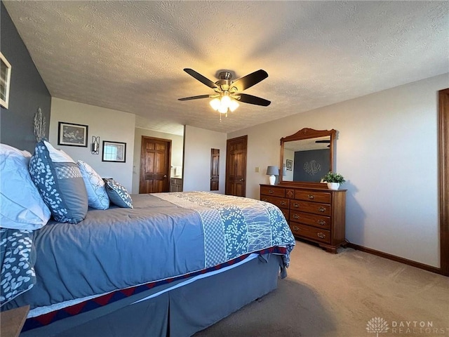 bedroom with light colored carpet, a textured ceiling, baseboards, and ceiling fan