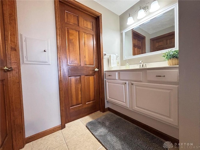 bathroom with tile patterned floors, baseboards, and vanity