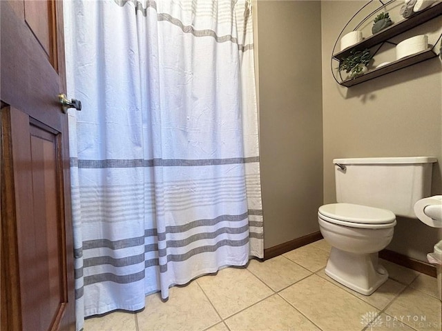 bathroom featuring baseboards, toilet, and tile patterned flooring