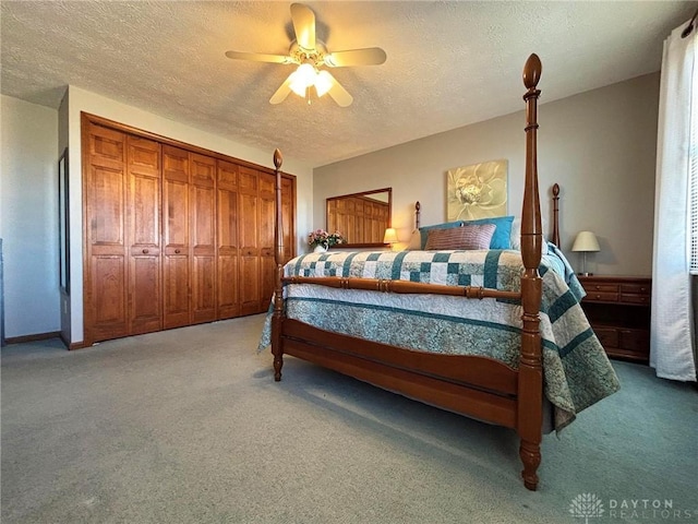 bedroom featuring ceiling fan, light colored carpet, and a textured ceiling