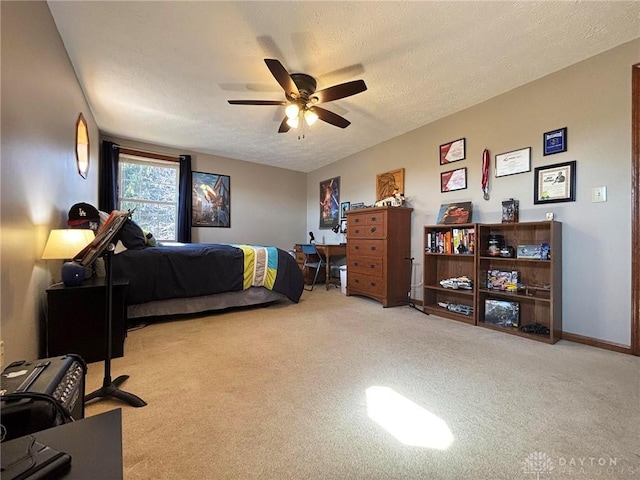 carpeted bedroom with a ceiling fan, baseboards, and a textured ceiling