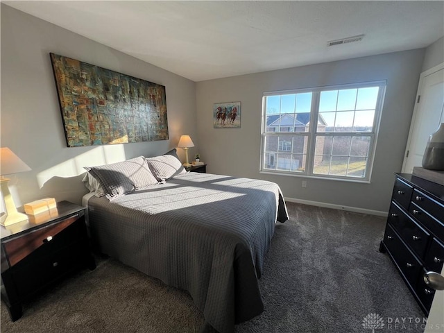 bedroom featuring dark colored carpet, visible vents, and baseboards