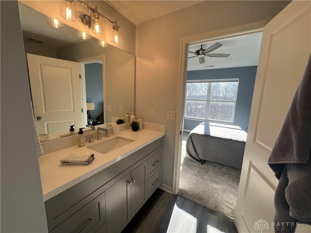 ensuite bathroom with visible vents, connected bathroom, ceiling fan, wood finished floors, and vanity