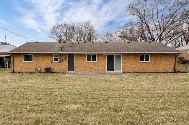 rear view of property featuring brick siding, a patio, a lawn, and fence