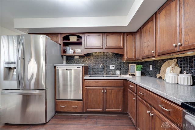 kitchen with a sink, tasteful backsplash, dark wood-type flooring, and appliances with stainless steel finishes