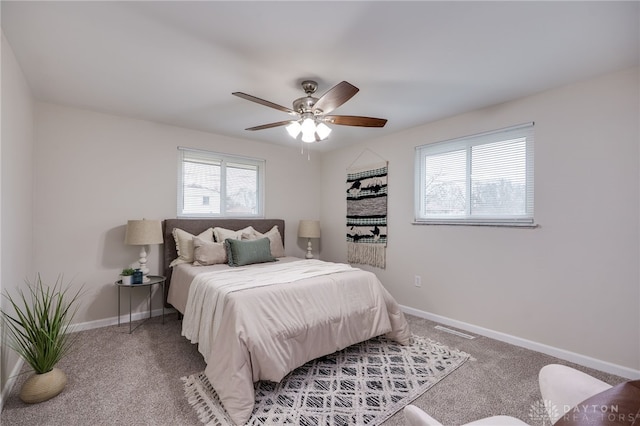 carpeted bedroom featuring visible vents, baseboards, and ceiling fan