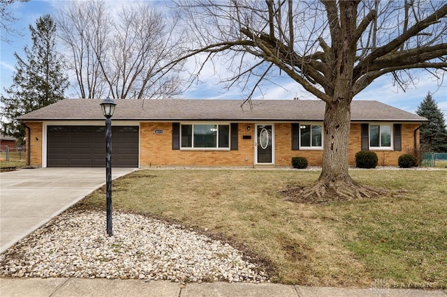 ranch-style house with a shingled roof, concrete driveway, a front lawn, a garage, and brick siding