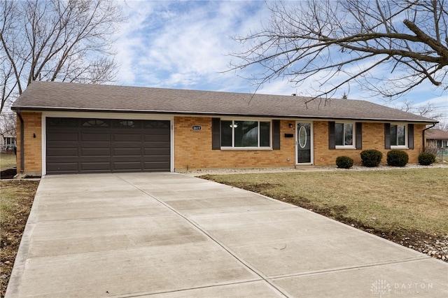 ranch-style house with brick siding, a shingled roof, a front lawn, concrete driveway, and an attached garage