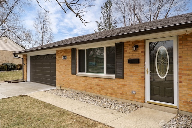 entrance to property with concrete driveway, brick siding, and a garage