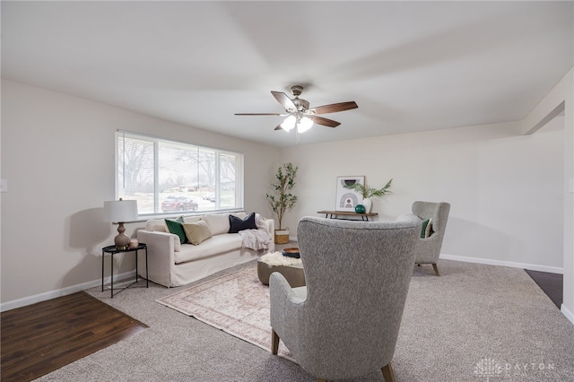 carpeted living area with a ceiling fan and baseboards