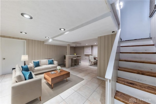 living room featuring recessed lighting, light tile patterned flooring, and stairs