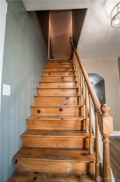 stairway featuring arched walkways