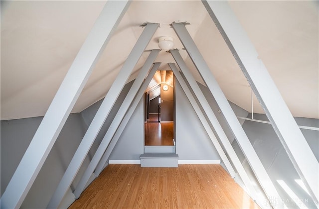 bonus room featuring vaulted ceiling, wood finished floors, and baseboards