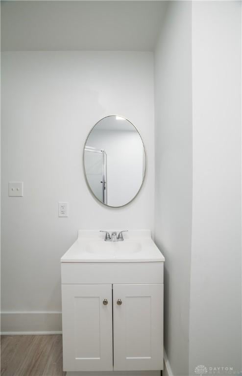 bathroom featuring baseboards, wood finished floors, and vanity