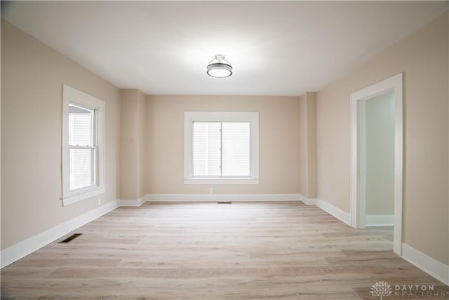 spare room featuring light wood-type flooring and baseboards