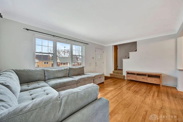 living room with light wood-type flooring and stairway