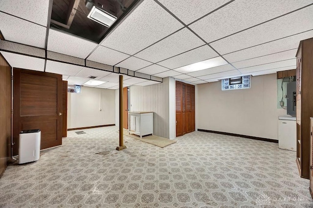 basement with baseboards, a paneled ceiling, and carpet