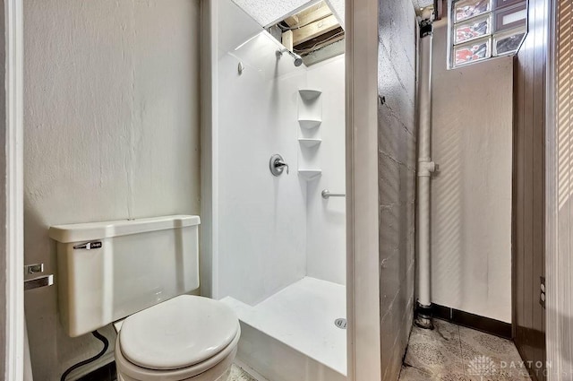 bathroom featuring a stall shower and toilet