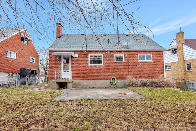 rear view of house with a gate, a lawn, and brick siding