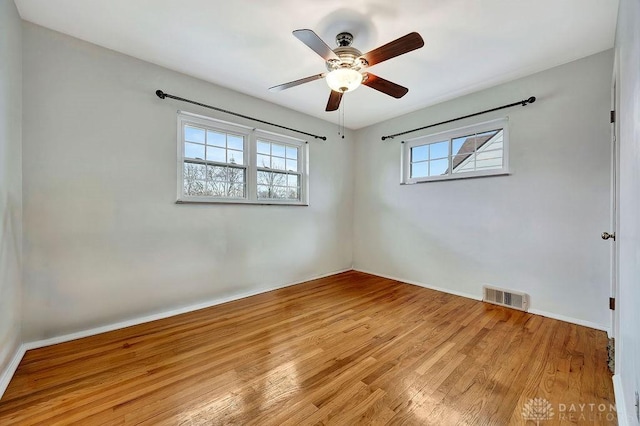 empty room with ceiling fan, visible vents, baseboards, and light wood-style flooring