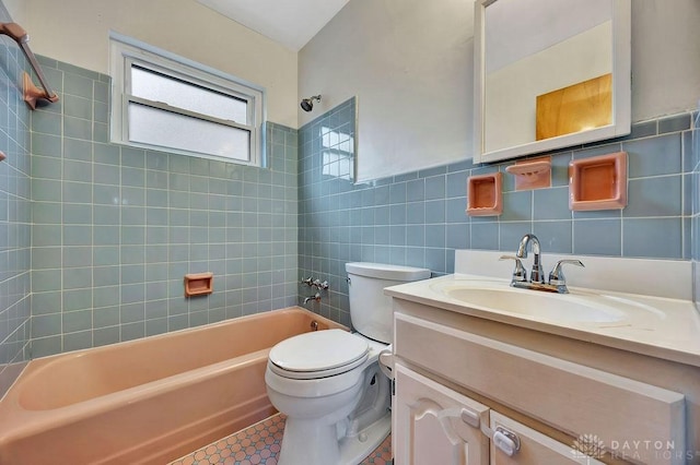 bathroom with tile patterned floors, toilet, shower / bathing tub combination, tile walls, and vanity