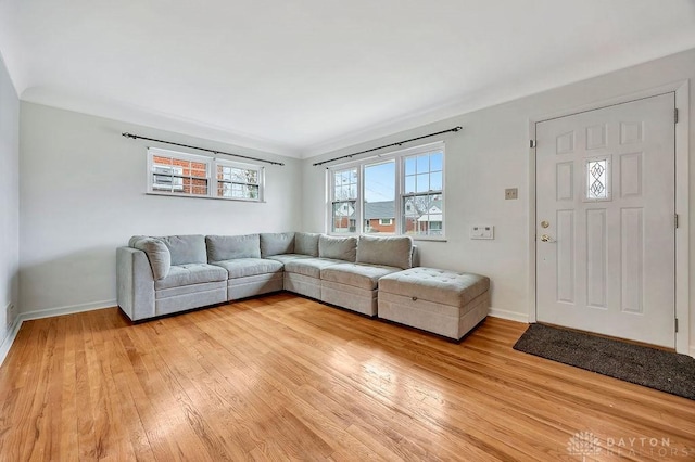 living area with baseboards and light wood finished floors