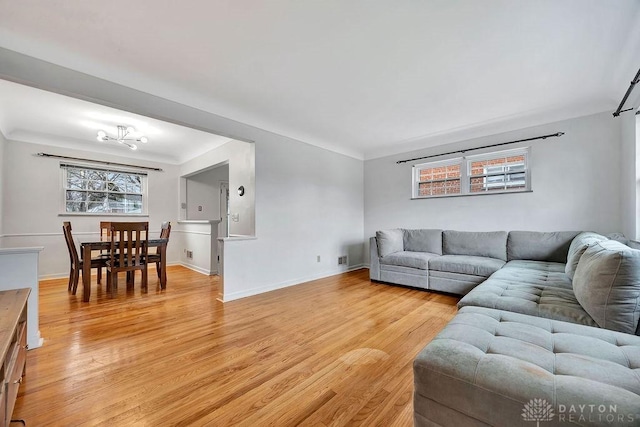 living area with baseboards and light wood finished floors