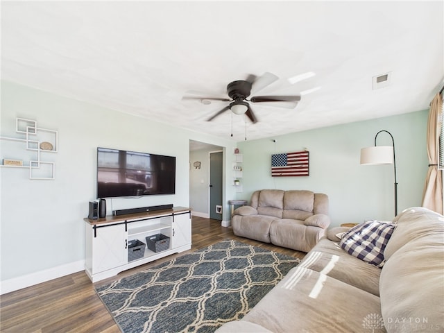 living area with ceiling fan, visible vents, baseboards, and dark wood-style floors