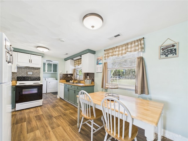 kitchen with visible vents, backsplash, range with electric cooktop, independent washer and dryer, and a sink