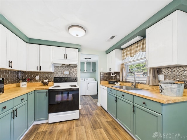 kitchen featuring washer and clothes dryer, visible vents, range with electric stovetop, and wood counters