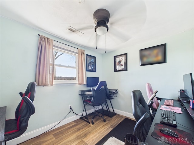 office area with ceiling fan, visible vents, baseboards, and wood finished floors