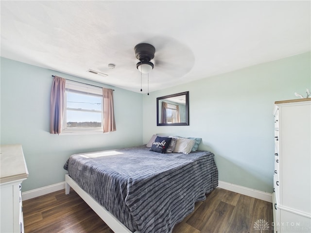 bedroom featuring visible vents, ceiling fan, baseboards, and wood finished floors