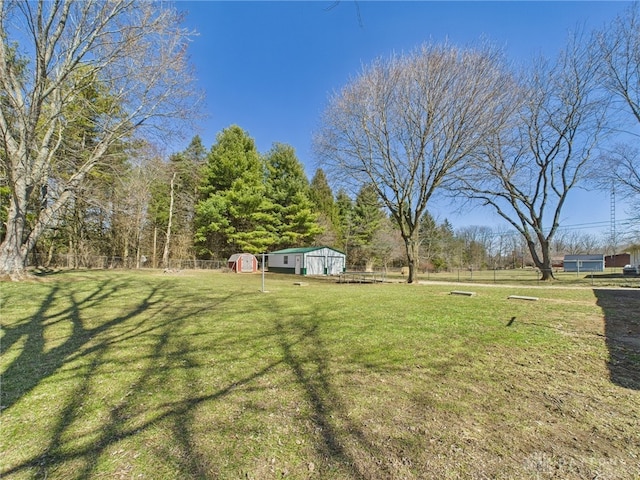 view of yard with an outdoor structure and fence