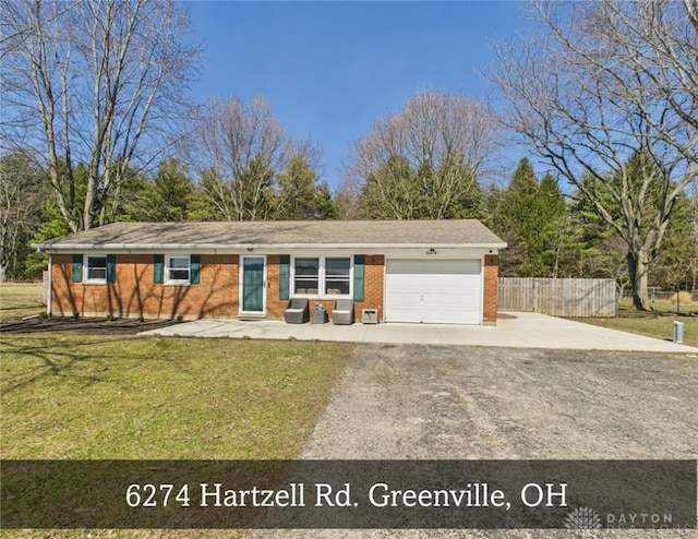 ranch-style home featuring driveway, a front lawn, fence, an attached garage, and brick siding