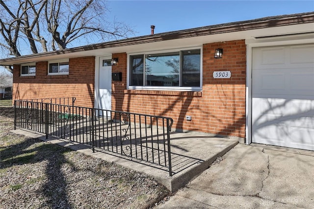 property entrance with a garage and brick siding