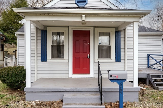 view of exterior entry with a shingled roof