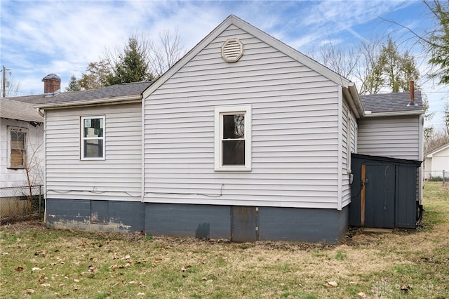 view of property exterior featuring a lawn and fence